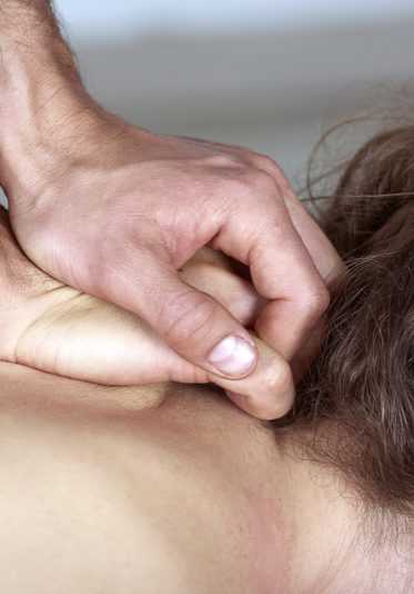 Young woman having chiropractic back adjustment